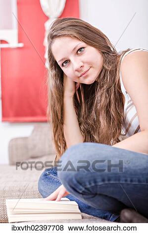 Stock Photo - Girl reading a book at home. Fotosearch