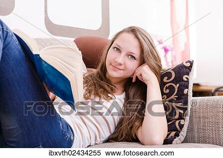 Girl reading a book on the sofa View Large Photo Image Stock Photography - Girl reading a book on the sofa. Fotosearch