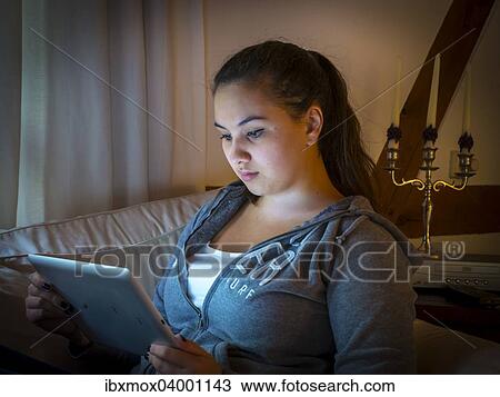 "Girl reading on a tablet computer at home, Germany, Europe" View Large Photo Image Stock Image - "Girl reading on a tablet computer at home, Germany, Europe". Fotosearch
