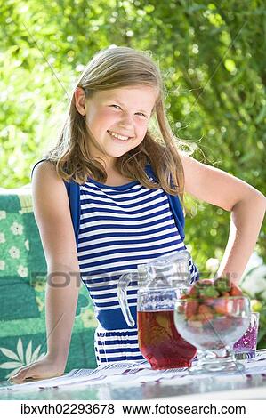 Girl standing at a garden table View Large Photo Image Stock Photo - Girl standing at a garden table. Fotosearch