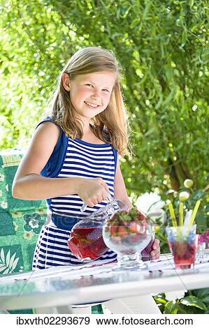Stock Photo - Girl standing at a garden table. Fotosearch