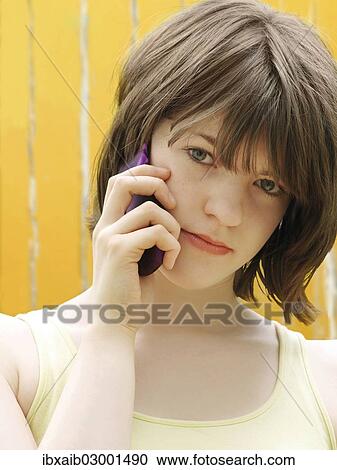Stock Image - "Girl, teenager, making a call on a mobile phone". Fotosearch