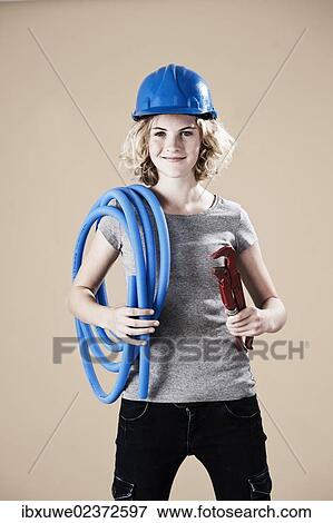 Girl wearing a hard hat and holding a pipe wrench View Large Photo Image Stock Photo - Girl wearing a hard hat and holding a pipe wrench. Fotosearch