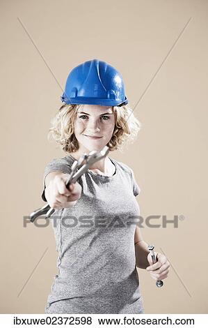 Girl wearing a hard hat and holding a spanner View Large Photo Image Stock Photo - Girl wearing a hard hat and holding a spanner. Fotosearch