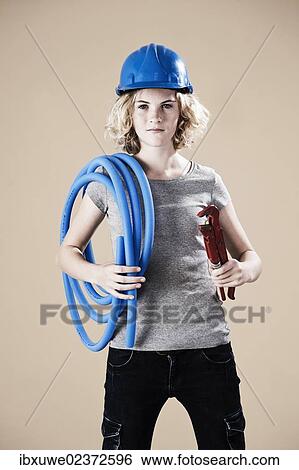 Girl wearing a hard hat and holding a pipe wrench View Large Photo Image Stock Photograph - Girl wearing a hard hat and holding a pipe wrench. Fotosearch