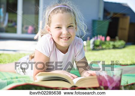 Girl with a book in the garden View Large Photo Image Stock Photo - Girl with a book in the garden. Fotosearch