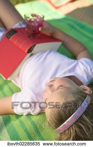 Stock Photography - Girl with a book in the garden. Fotosearch
