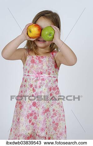 Girl with a red and a green apple in front of her face View Large Photo Image Stock Image - Girl with a red and a green apple in front of her face. Fotosearch