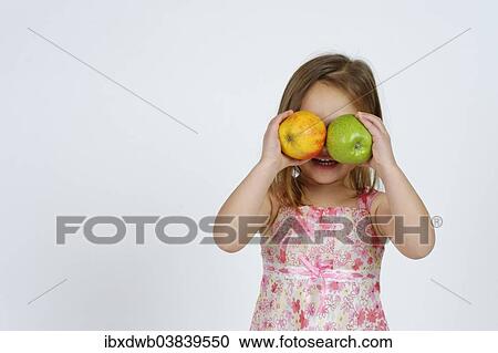 Girl with a red and a green apple in front of her face View Large Photo Image Stock Image - Girl with a red and a green apple in front of her face. Fotosearch