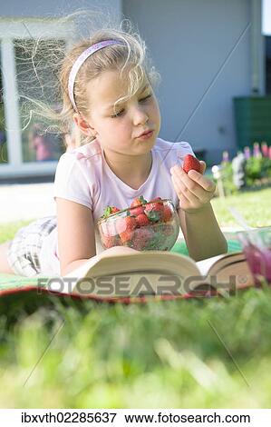 Girl with strawberries and a book in the garden View Large Photo Image Stock Photo - Girl with strawberries and a book in the garden. Fotosearch