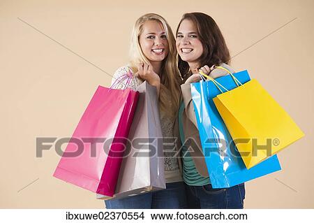 Girlfriends with shopping bags while shopping together View Large Photo Image Picture - Girlfriends with shopping bags while shopping together. Fotosearch