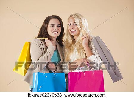 Girlfriends with shopping bags while shopping together View Large Photo Image Stock Photo - Girlfriends with shopping bags while shopping together. Fotosearch
