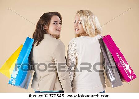 Girlfriends with shopping bags while shopping together View Large Photo Image Stock Photography - Girlfriends with shopping bags while shopping together. Fotosearch