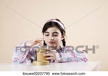 Girls nibbling enjoyably from a jar of honey View Large Photo Image Stock Image - Girls nibbling enjoyably from a jar of honey. Fotosearch
