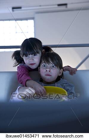Girls with popcorn watching television View Large Photo Image Stock Image - Girls with popcorn watching television. Fotosearch