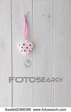 Glass heart hanging on a white wooden wall View Large Photo Image Stock Photograph - Glass heart hanging on a white wooden wall. Fotosearch