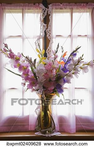 "Glass vase with silk flowers on the window sill of an old reconstructed 1983 Canadiana cottage style residential log home, Quebec, Canada, North America" View Large Photo Image Stock Photo - "Glass vase with silk flowers on the window sill of an old reconstructed 1983 Canadiana cottage style residential log home, Quebec, Canada, North America". Fotosearch