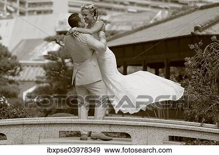Groom lifting the bride up in the air View Large Photo Image Stock Photo - Groom lifting the bride up in the air. Fotosearch