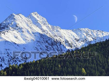 Stock Image - "Half moon over snowy peaks, Ahornspitz, Zillertal Alps, Brandberg, Zillertal Alps main ridge, Tyrol, Austria, Europe". Fotosearch
