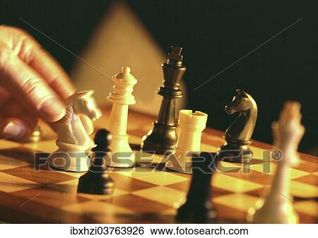 Stock Photograph - Hand moving a chess piece. Fotosearch