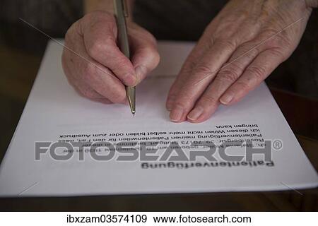 Stock Photo - "Hands of a 82-year-old woman signing a living will, Germany, Europe". Fotosearch