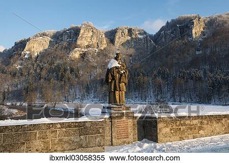 "Hausener Bridge with the statue of St. Nepomuk in front of the Hausener Zinnen rocks in the evening light, Hausen im Tal, Donautal, Baden-Wurttemberg, Germany, Europe" View Large Photo Image Stock Photography - "Hausener Bridge with the statue of St. Nepomuk in front of the Hausener Zinnen rocks in the evening light, Hausen im Tal, Donautal, Baden-Wurttemberg, Germany, Europe". Fotosearch