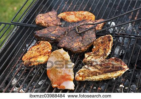 Heavily roasted meat on a charcoal grill View Large Photo Image Picture - Heavily roasted meat on a charcoal grill. Fotosearch