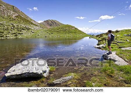 "Hiker at the lake below the summit of Mt Hochwart or Guardia Alta, climbing Mt Ultner Hochwart or Vedetta Alta in Ulten Valley or Val d'Ultimo, Mt Kornigl in the back, Ulten, South Tyrol, Europe" View Large Photo Image Stock Image - "Hiker at the lake below the summit of Mt Hochwart or Guardia Alta, climbing Mt Ultner Hochwart or Vedetta Alta in Ulten Valley or Val d'Ultimo, Mt Kornigl in the back, Ulten, South Tyrol, Europe". Fotosearch