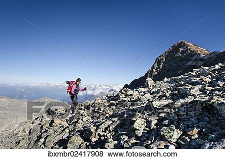 Stock Photo - "Hiker climbing Fernerkoepfl mountain, above Rieserfernerhuette mountain shelter, Rieserfernergruppe mountain group, Puster valley, Schneebiger Nock mountain at the back, province of Bolzano-Bozen, Italy, Europe". Fotosearch