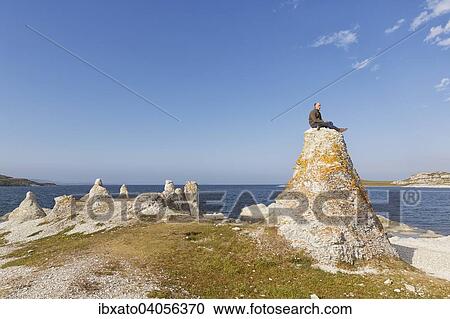 "Hiker sitting on one of the legendary dolomite rocks on Porsangerfjorden fjord, near Lakselv, Porsanger, Porsa? ïgu, Porsanki, Finnmark County, Norway, Europe" View Large Photo Image Stock Image - "Hiker sitting on one of the legendary dolomite rocks on Porsangerfjorden fjord, near Lakselv, Porsanger, Porsa? ïgu, Porsanki, Finnmark County, Norway, Europe". Fotosearch