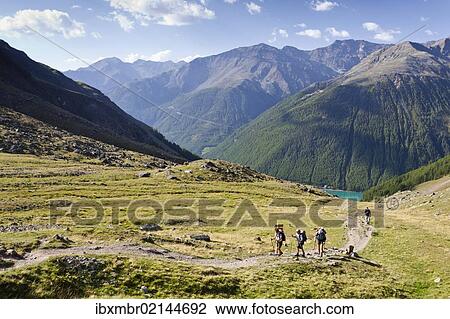 Stock Image - "Hikers ascending to the Similaun Hut, Schnalstal Valley through Tisental Valley, with th Vernagt Reservoir below, Alto Adige, Italy, Europe". Fotosearch