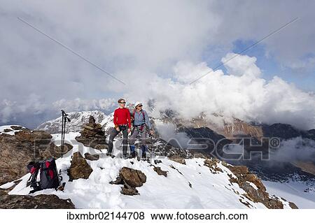 "Hikers on Lorcherspitz Mountain above Gruensee Lake, looking towards Weissbrunnspitze and Zufrittspitze Mountains with high fog, Alto Adige, Italy, Europe" View Large Photo Image Stock Photo - "Hikers on Lorcherspitz Mountain above Gruensee Lake, looking towards Weissbrunnspitze and Zufrittspitze Mountains with high fog, Alto Adige, Italy, Europe". Fotosearch