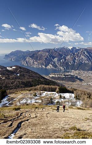 "Hikers on their way to Monte Stivo mountain above St. Barbara on Lake Garda, the village of Riva on Lake Garda at the back, Trentino province, Italy, Europe" View Large Photo Image Stock Photo - "Hikers on their way to Monte Stivo mountain above St. Barbara on Lake Garda, the village of Riva on Lake Garda at the back, Trentino province, Italy, Europe". Fotosearch