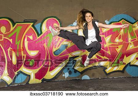 "Hip-hop dancer jumping in front of a wall with graffiti, Bad Cannstatt, Stuttgart, Baden-Wurttemberg, Germany, Europe" View Large Photo Image Stock Image - "Hip-hop dancer jumping in front of a wall with graffiti, Bad Cannstatt, Stuttgart, Baden-Wurttemberg, Germany, Europe". Fotosearch