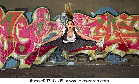 "Hip-hop dancer jumping in front of a wall with graffiti, Bad Cannstatt, Stuttgart, Baden-Wurttemberg, Germany, Europe" View Large Photo Image Stock Photo - "Hip-hop dancer jumping in front of a wall with graffiti, Bad Cannstatt, Stuttgart, Baden-Wurttemberg, Germany, Europe". Fotosearch