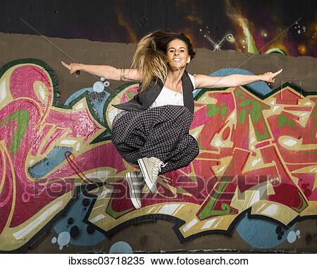 "Hip-hop dancer jumping in front of a wall with graffiti, Bad Cannstatt, Stuttgart, Baden-Wurttemberg, Germany, Europe" View Large Photo Image Stock Photography - "Hip-hop dancer jumping in front of a wall with graffiti, Bad Cannstatt, Stuttgart, Baden-Wurttemberg, Germany, Europe". Fotosearch