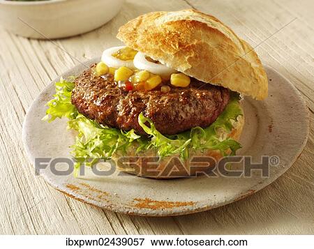 Home-made burger in a crusty roll with sweetcorn relish and onion View Large Photo Image Stock Photo - Home-made burger in a crusty roll with sweetcorn relish and onion. Fotosearch