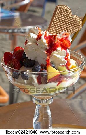 Stock Photograph - Ice cream with fruit and whipped cream. Fotosearch