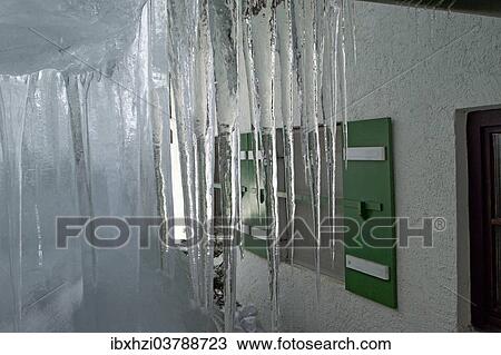Stock Image - Icicles on a house in the Alps. Fotosearch