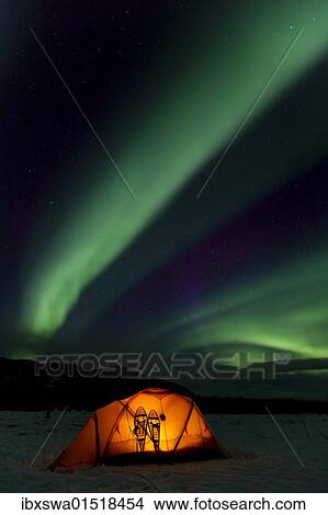Picture - "Illuminated expedition tent and traditional wooden snow shoes, Northern Lights, Polar Lights, Aurora Borealis, green, purple, blue, near Whitehorse, Yukon Territory, Canada, North America". Fotosearch