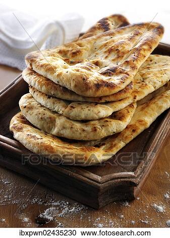 Indian naan bread with garlic and coriander View Large Photo Image Stock Image - Indian naan bread with garlic and coriander. Fotosearch