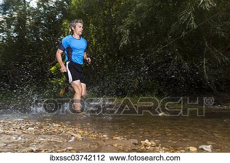 "Jogger running through a stream, Winterbach, Baden-Wurttemberg, Germany, Europe" View Large Photo Image Stock Image - "Jogger running through a stream, Winterbach, Baden-Wurttemberg, Germany, Europe". Fotosearch