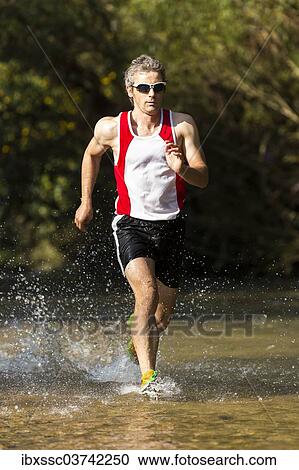 "Jogger running through a stream, Winterbach, Baden-Wurttemberg, Germany, Europe" View Large Photo Image Stock Image - "Jogger running through a stream, Winterbach, Baden-Wurttemberg, Germany, Europe". Fotosearch