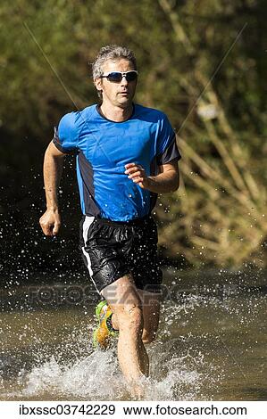 "Jogger running through a stream, Winterbach, Baden-Wurttemberg, Germany, Europe" View Large Photo Image Stock Photo - "Jogger running through a stream, Winterbach, Baden-Wurttemberg, Germany, Europe". Fotosearch