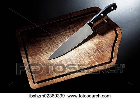 Kitchen knife on a cutting board View Large Photo Image Stock Photo - Kitchen knife on a cutting board. Fotosearch