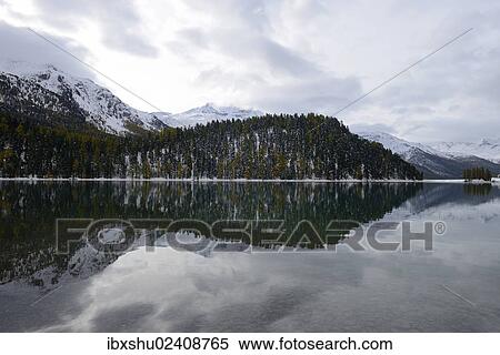 Stock Photography - "Lake Champfer with a reflection of forest and mountains, St. Moritz, Grisons, Engadine, Switzerland, Europe". Fotosearch
