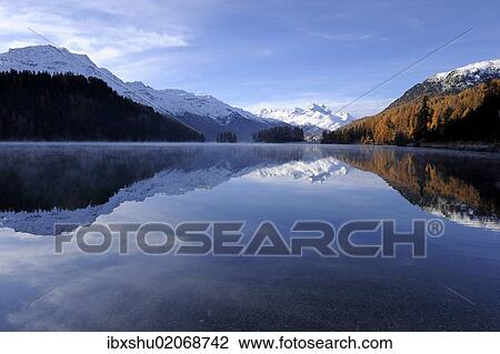 Stock Image - "Lake Champfer with larch forest with autumnal colouring, Mt Piz da la Margna at back, St. Moritz, Engadine, Grisons, Switzerland, Europe". Fotosearch