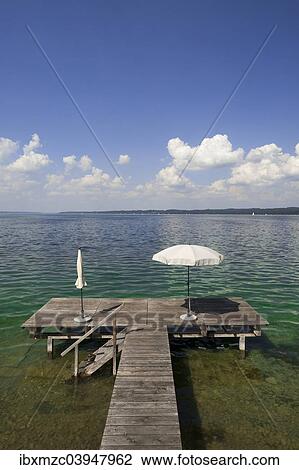 Stock Image - "Lake Starnberg with bathing jetty and parasol, Seeshaupt, Upper Bavaria, Bavaria, Germany, Europe". Fotosearch