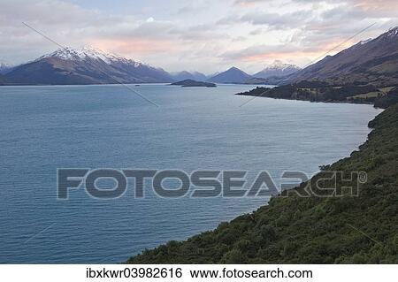 "Lake Wakatipu in front of a mountain range at sunrise, Otago Region, South Island, New Zealand, Oceania" View Large Photo Image Stock Photograph - "Lake Wakatipu in front of a mountain range at sunrise, Otago Region, South Island, New Zealand, Oceania". Fotosearch