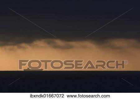 "Large container ship on the darkened horizon at sunset, Hirtshals, Denmark, Scandinavia, Europe" View Large Photo Image Stock Image - "Large container ship on the darkened horizon at sunset, Hirtshals, Denmark, Scandinavia, Europe". Fotosearch